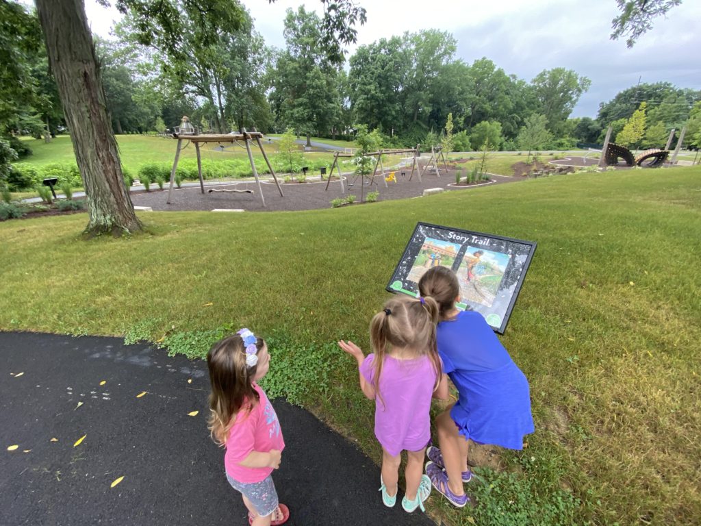 Three girls reading the story trail signage at Johnston-McVay Park in Westerville.