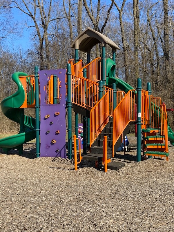The play structure with a rock climbing wall.