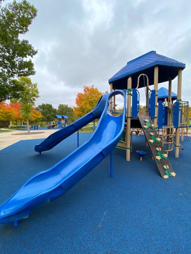 Two tall slides and a climbing wall on the playground.