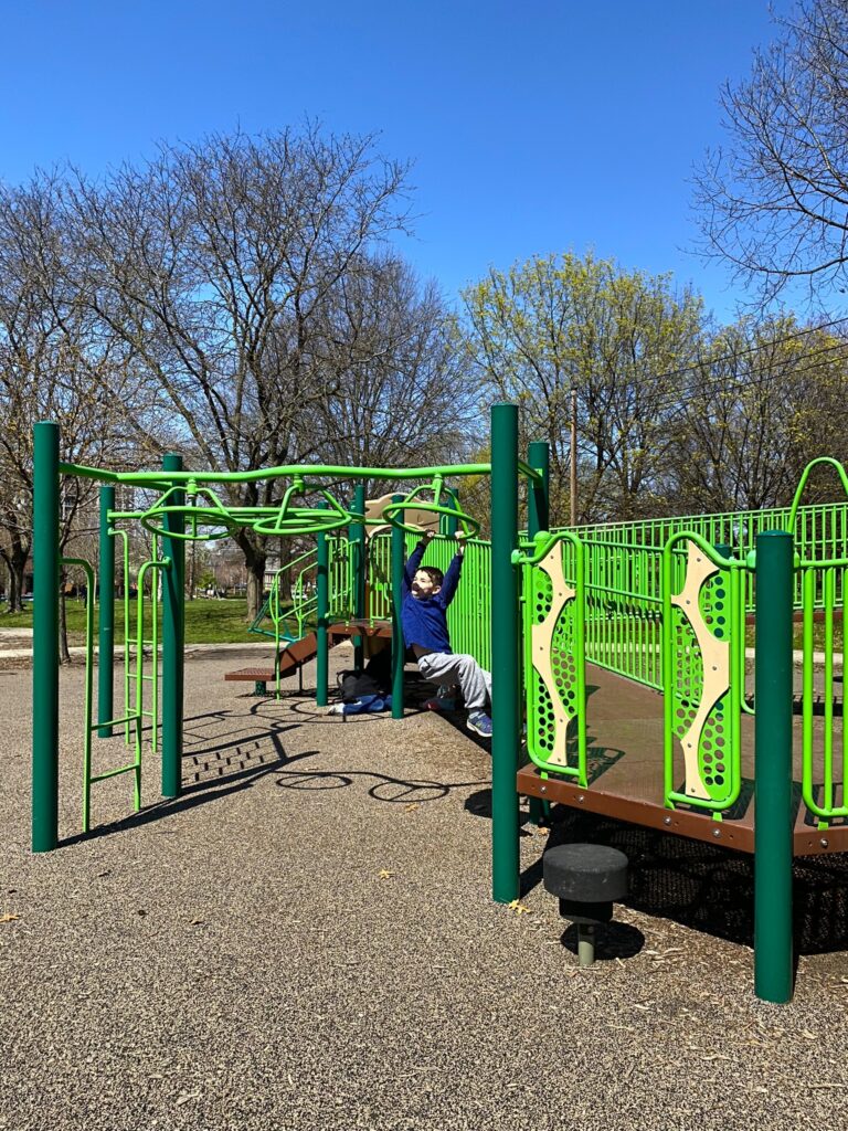A boy crossing the monkey bars at Goodale Park.