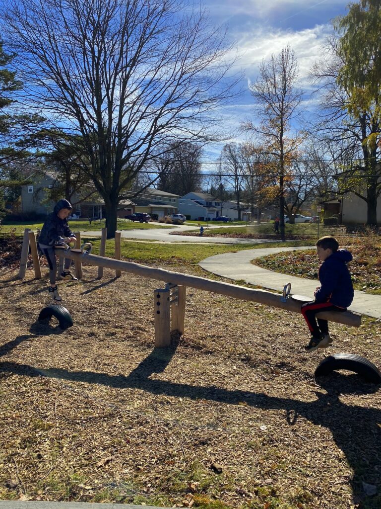 Two boys on a teeter totter.