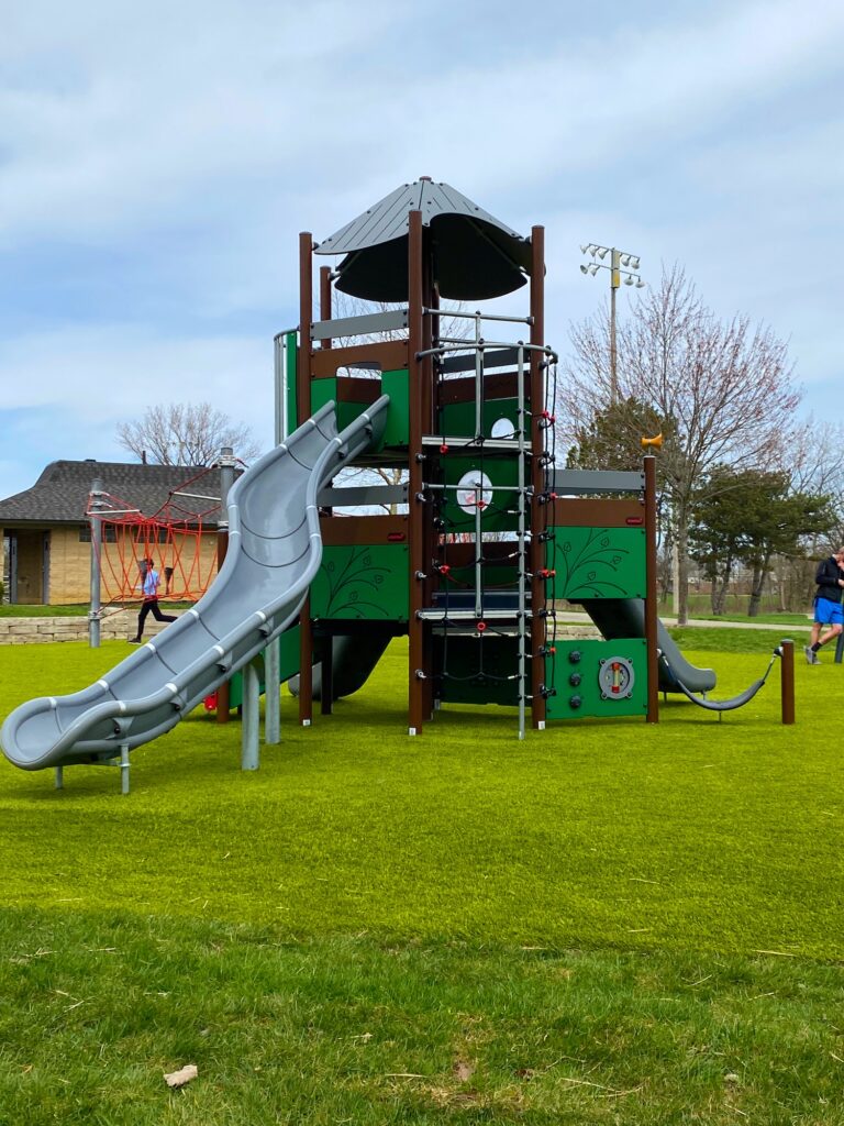 A tall play structure with a long slide at Perry Park.