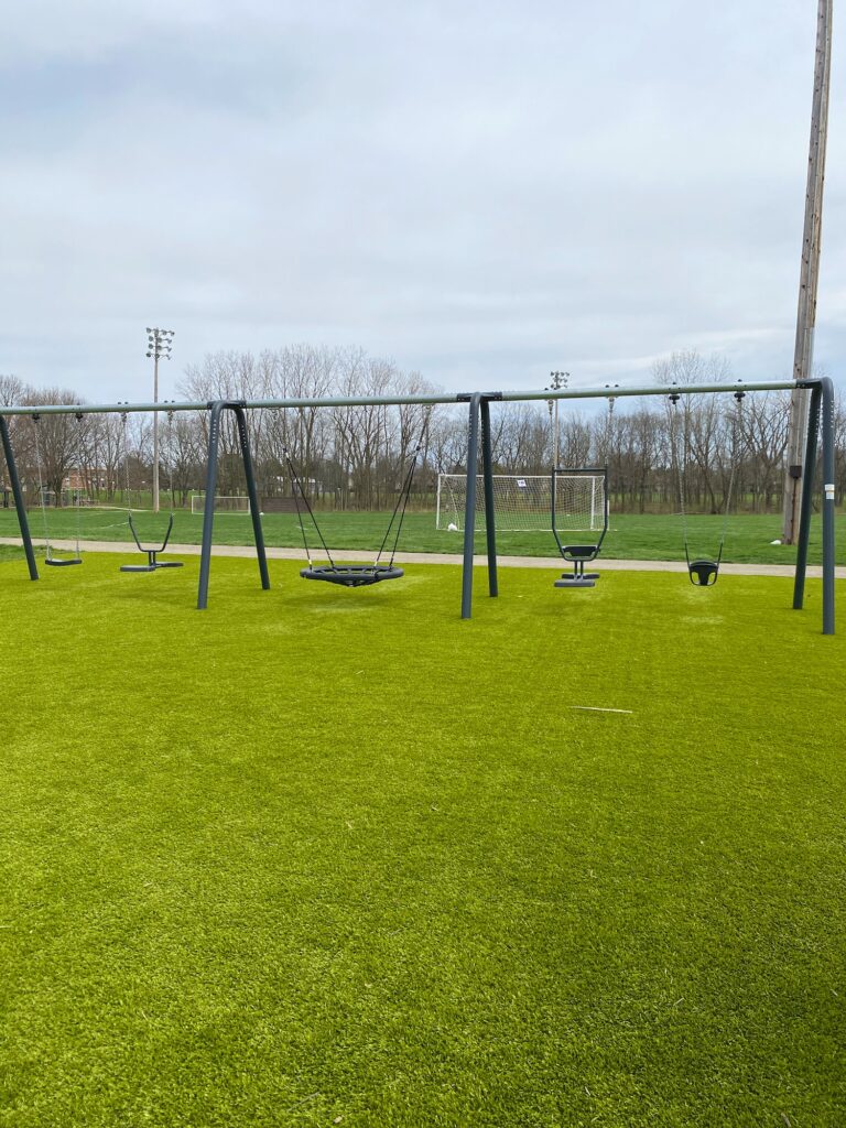 A full view of the swing set at Perry Park including 5 different kinds of swings.