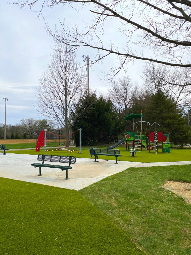 The toddler playground at Perry Park with benches in front.
