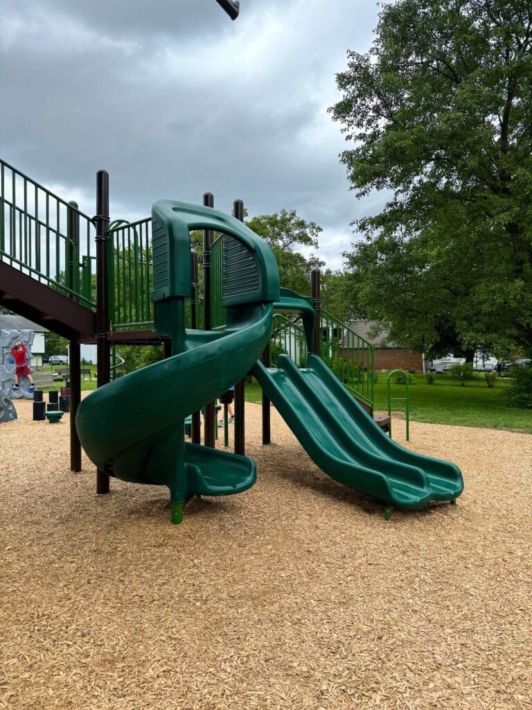 A small twisty slide and a double slide at the playground.