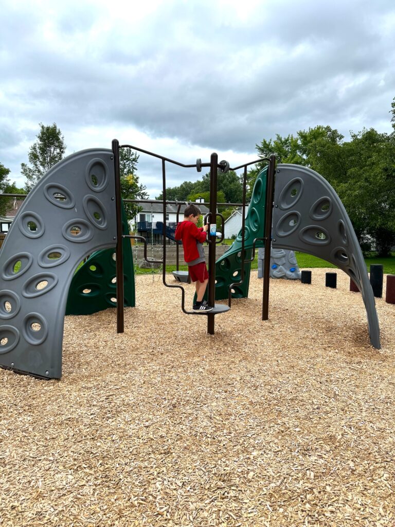 A boy playing on the playground at Ambassador Commons.