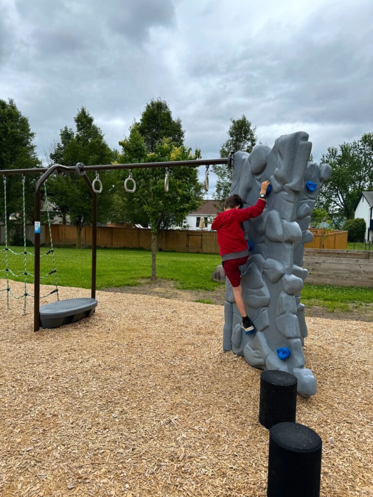 A boy on the rock climbing wall at Ambassador Commons Park in Gahanna.