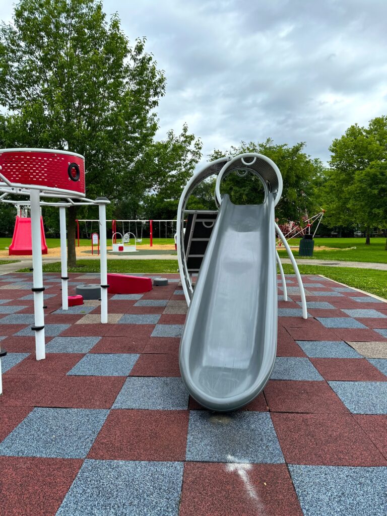 A grey slide on the main play structure in the park.