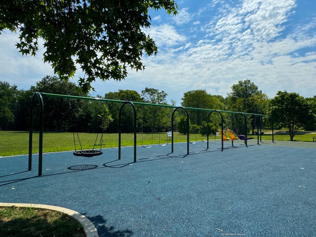 A large set of swings on the playground.