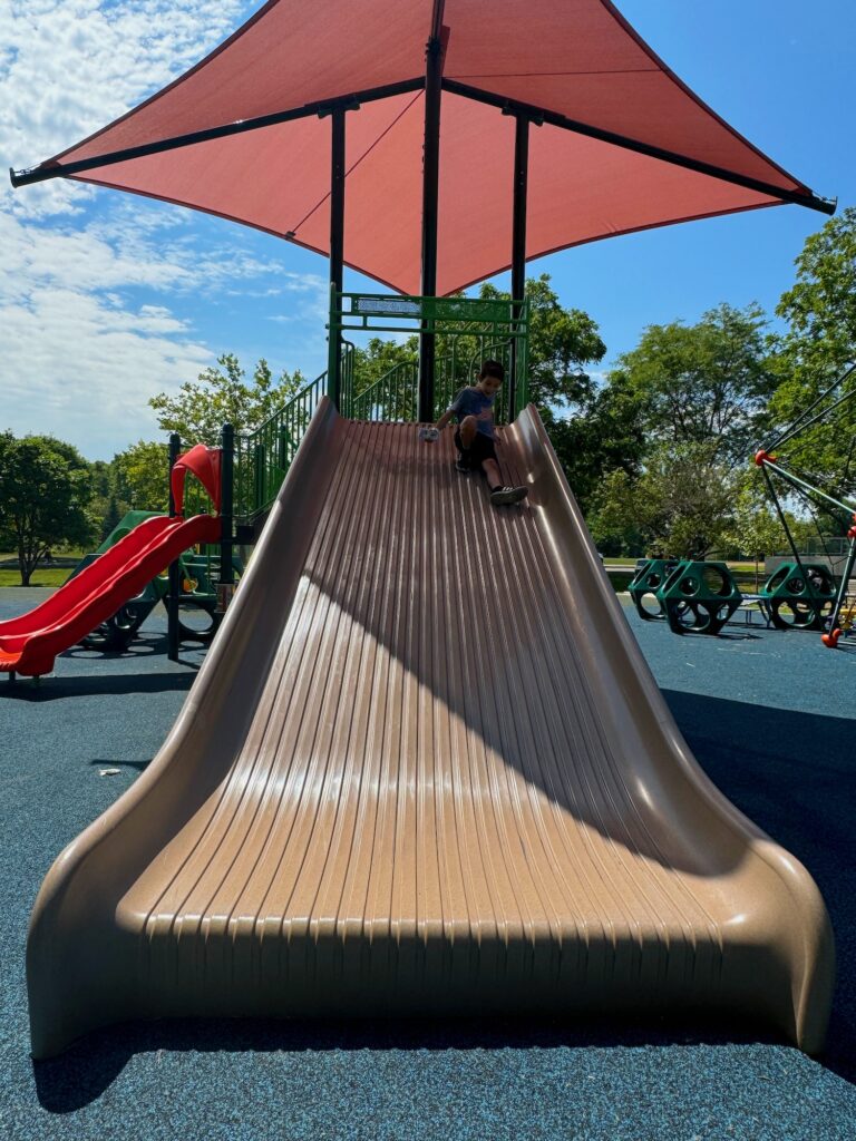 A boy on an extra wide slide.